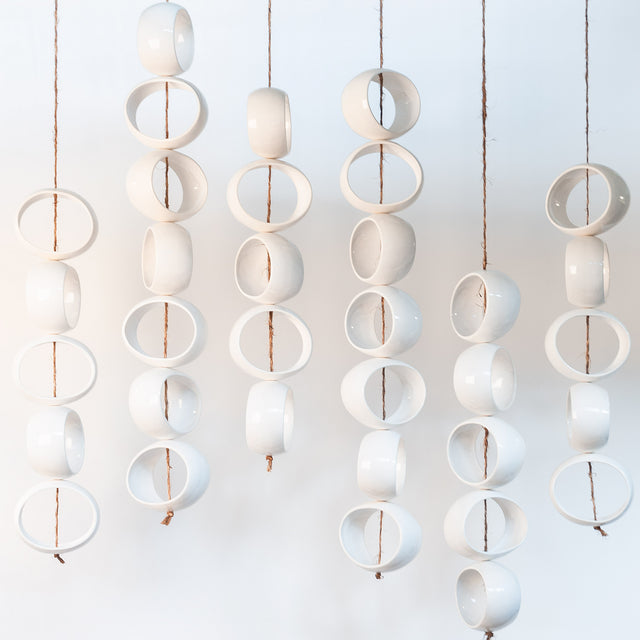 White Orb Sculpture, suspended white stoneware orbs on hand-knotted jute rope, by Jim Schatz