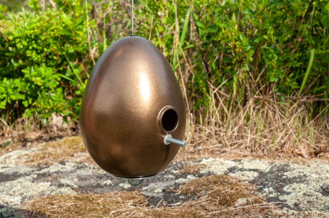 bronze ceramic Egg bird house hanging over moss and rock, J Schatz