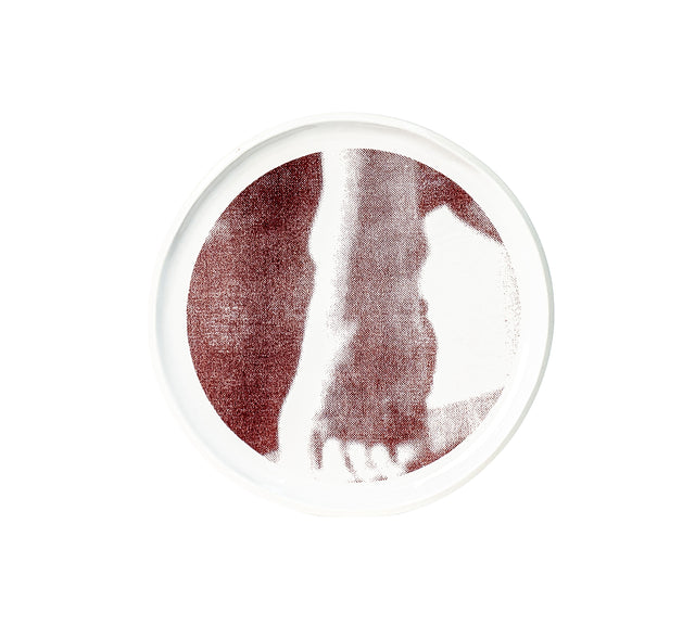 Photographic transfer of a forearm pressed against the body on stoneware Gestures plate, J Schatz.