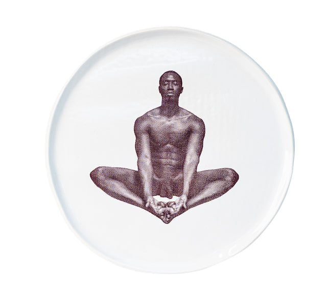 Photographic transfer of a seated figure with soles together on stoneware Gestures plate, J Schatz.