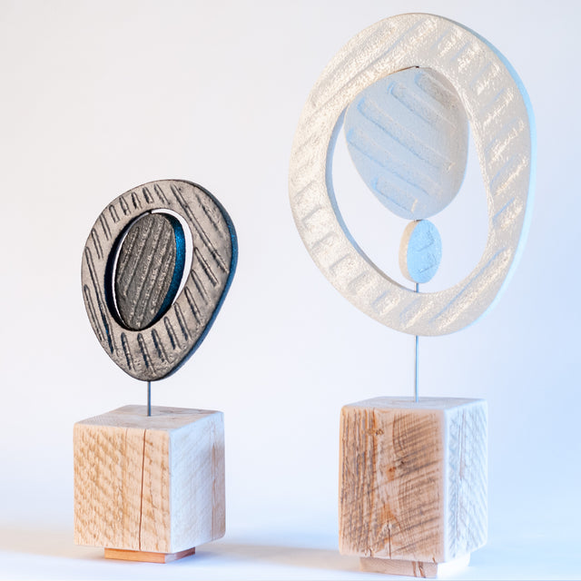 Zen sculptures, paired stoneware forms on carved wood bases, by Jim Schatz and Peter Souza Jr.