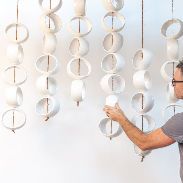 White Orb Sculpture, suspended white stoneware orbs on jute rope, by Jim Schatz